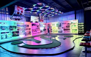 Indoor slot car racing track with neon lights and vibrant walls.