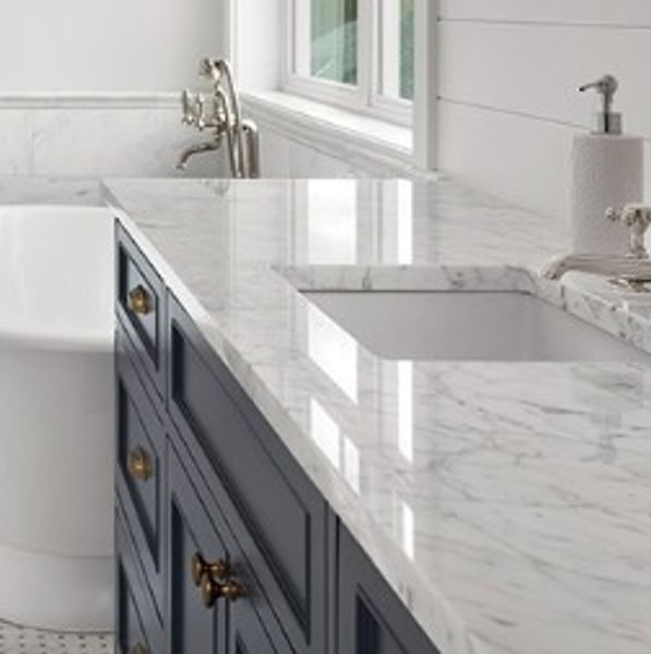 Marble bathroom countertop with blue cabinetry and undermount sink.