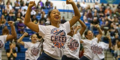 Cheerleaders perform energetically at a school event.