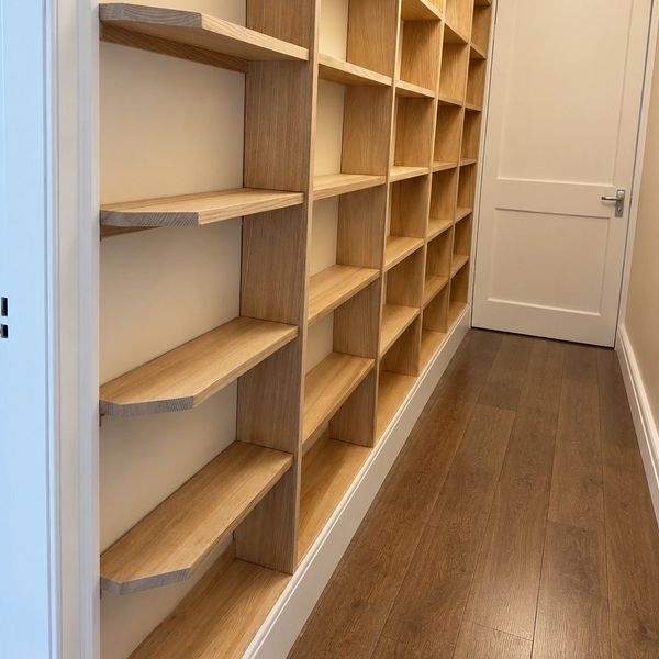 Empty wooden bookshelves along a hallway.