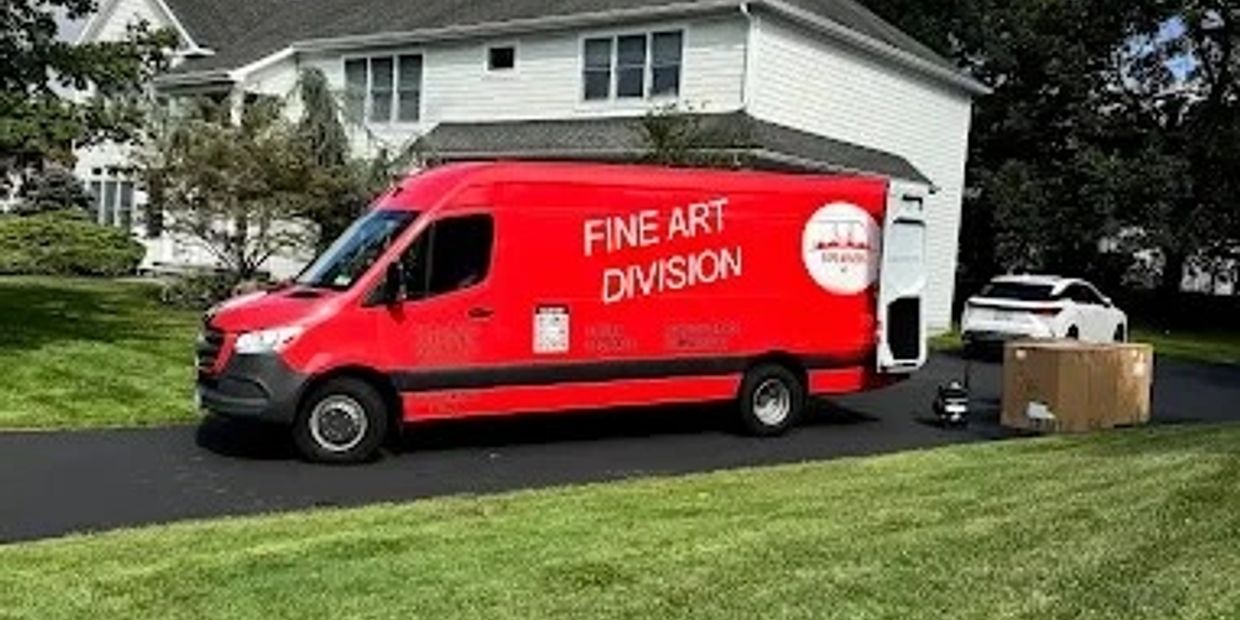 Red Fine Art Division van parked in driveway beside a white house.