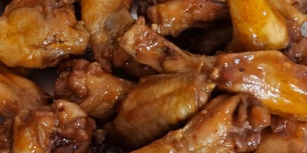 Chicken Wings and Legs With Sauce Drizzled on Top
