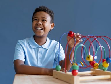 Happy boy playing with bead maze toy.