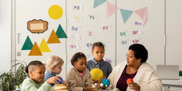 Teacher and children exploring the solar system model.