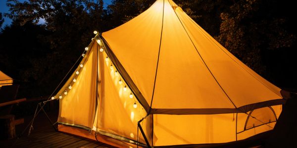 Glowing tent lit at night with string lights.