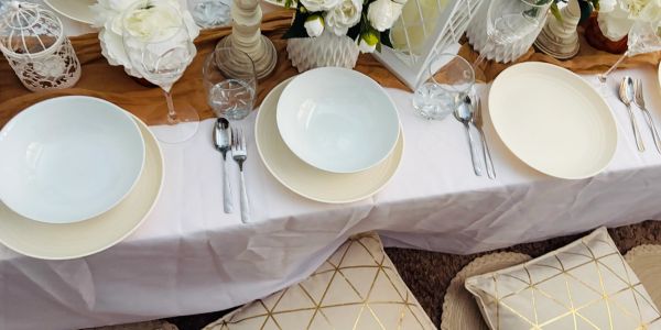 Elegant table setting with white plates and floral decorations.