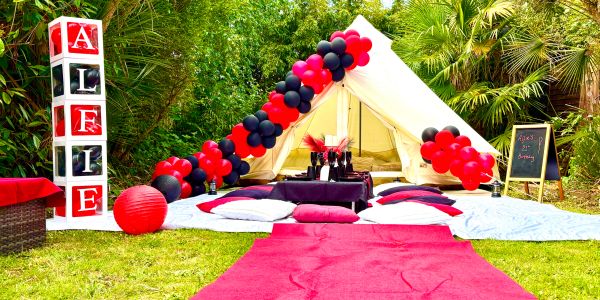 Outdoor tent setup with red and black decorations.