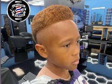 Young boy with a stylish, high-top fade haircut in a modern barbershop.