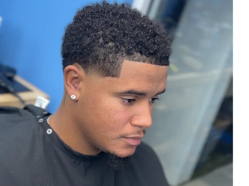 Young man with a fresh, sharp haircut and a fade.