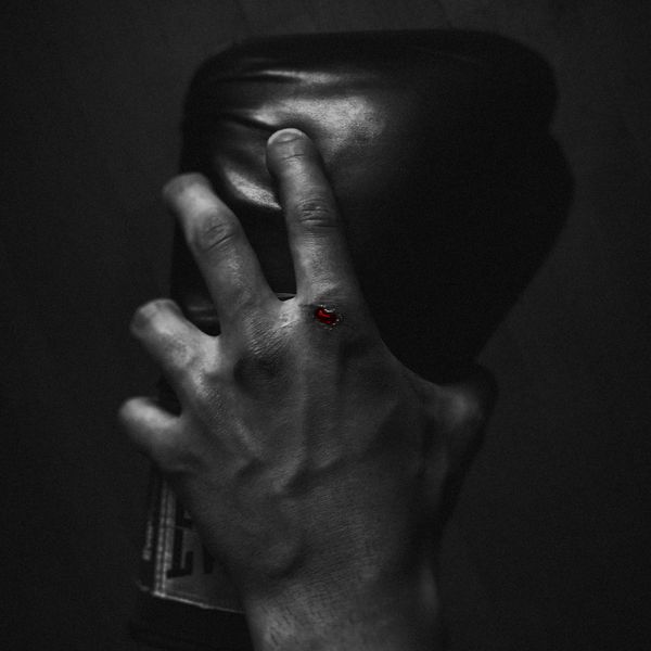 Battle damaged hand holding boxing glove after self-defense mma, kickboxing, jeetkune do class.