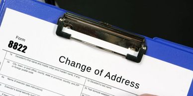 A clipboard holding a Change of Address form labeled Form 8822.