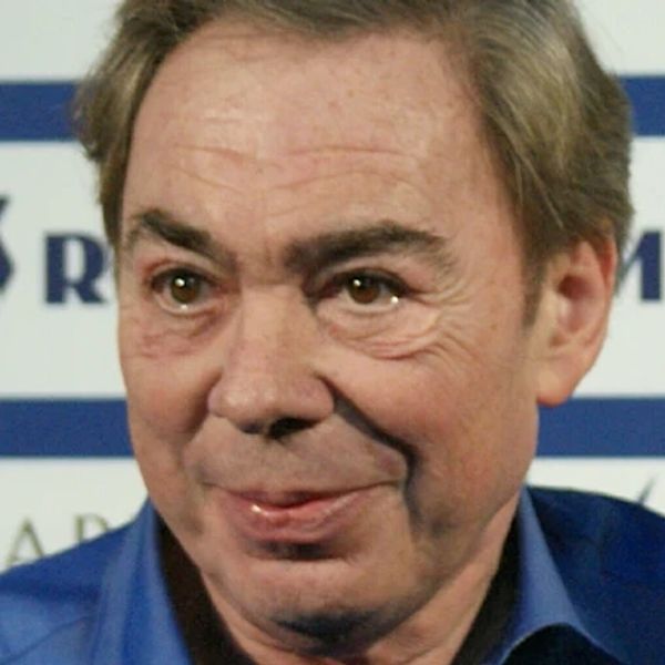 Man in blue shirt smiling at a press event.