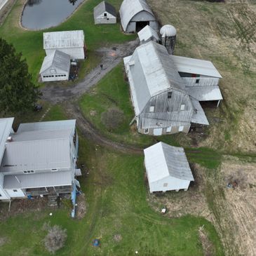 Aerial view of a rural farm with multiple barns and buildings.