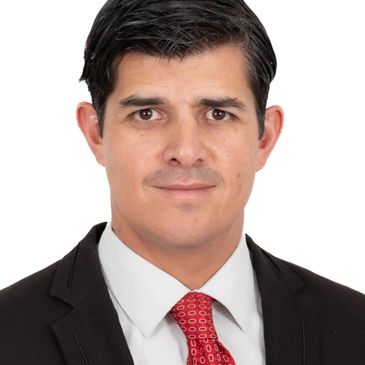 Professional headshot of a man in a suit with a red tie.