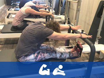 Group exercising on reformer machines in a fitness studio.