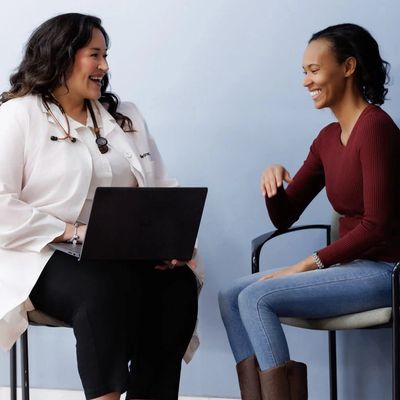 Doctor and patient sharing a joyful conversation during a consultation.