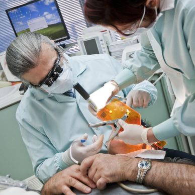 Dentist and assistant performing a dental procedure on a patient.