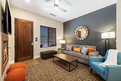 Modern living room with gray sofa, blue armchair, and warm wood accents.