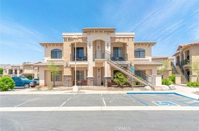 Modern two-story apartment building with exterior stairs and balconies.