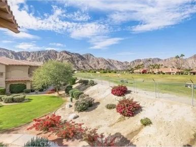 Golf course with desert landscaping and mountain backdrop on a sunny day.
