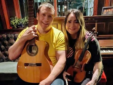Man and woman holding musical instruments.