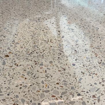 Polished terrazzo floor with mixed stone fragments reflecting light.