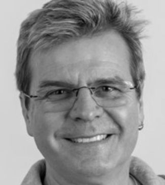 Smiling middle-aged man wearing glasses.