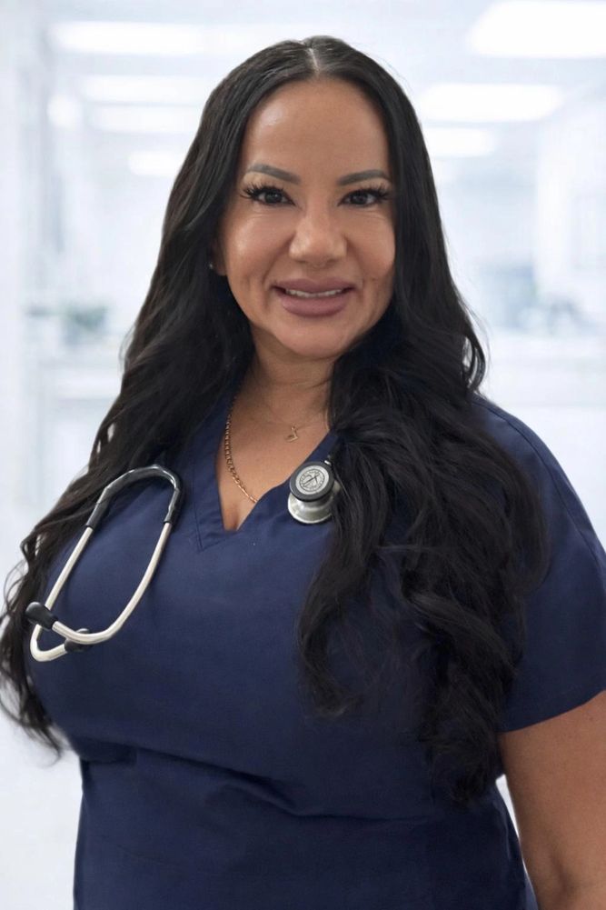 Smiling female healthcare professional in navy scrubs with stethoscope.