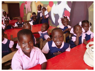 Children happily sitting in a colorful classroom with murals.