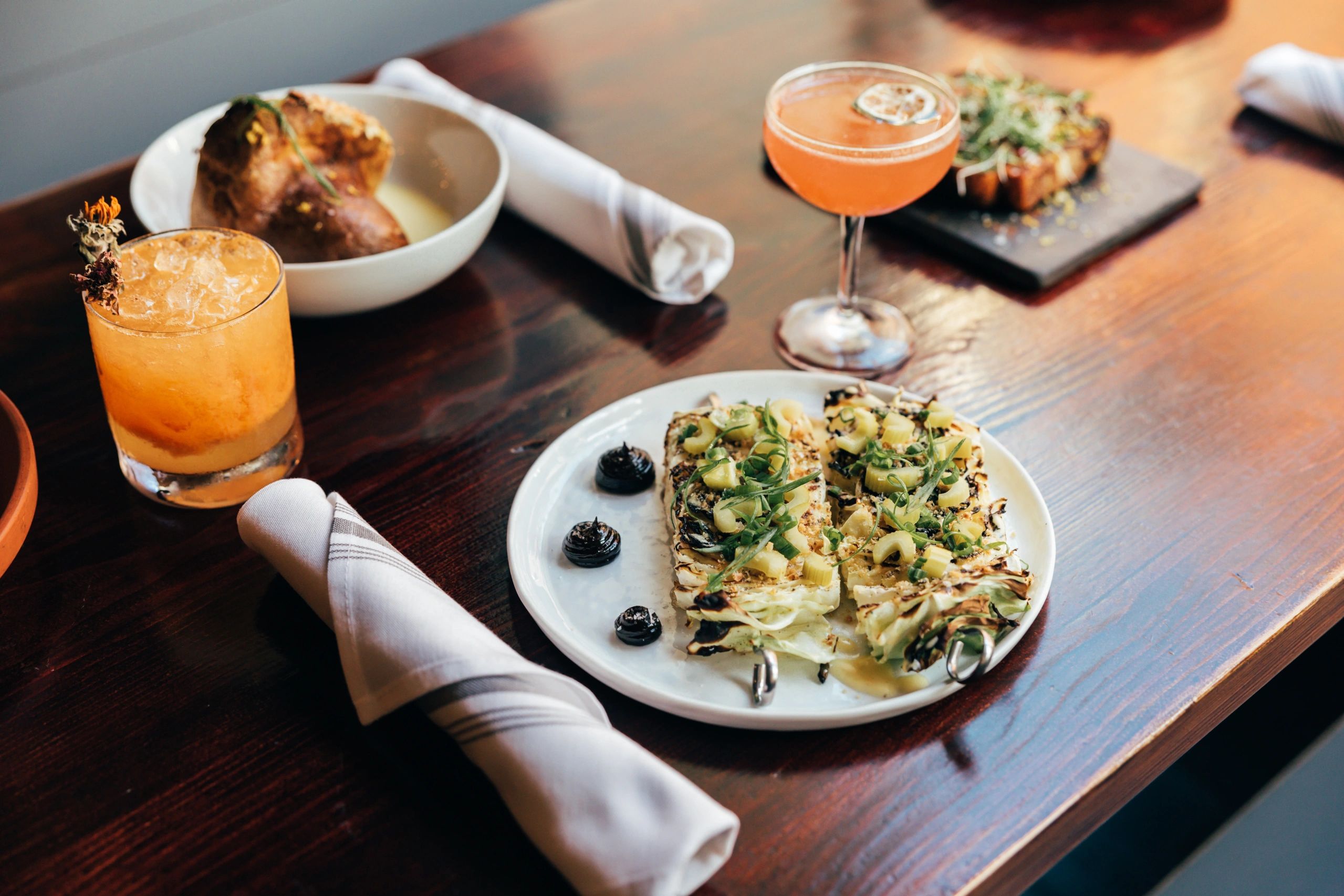 Chef's table at Sur Lie with plates of food and drinks.  

Photo Credit: Dawson Renaud