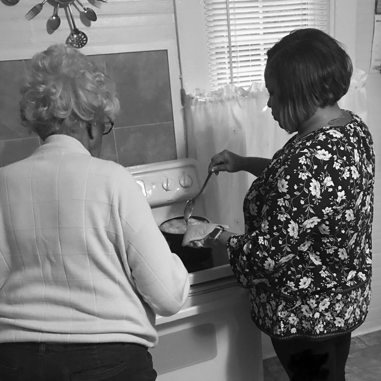 Two women cooking together in a kitchen.