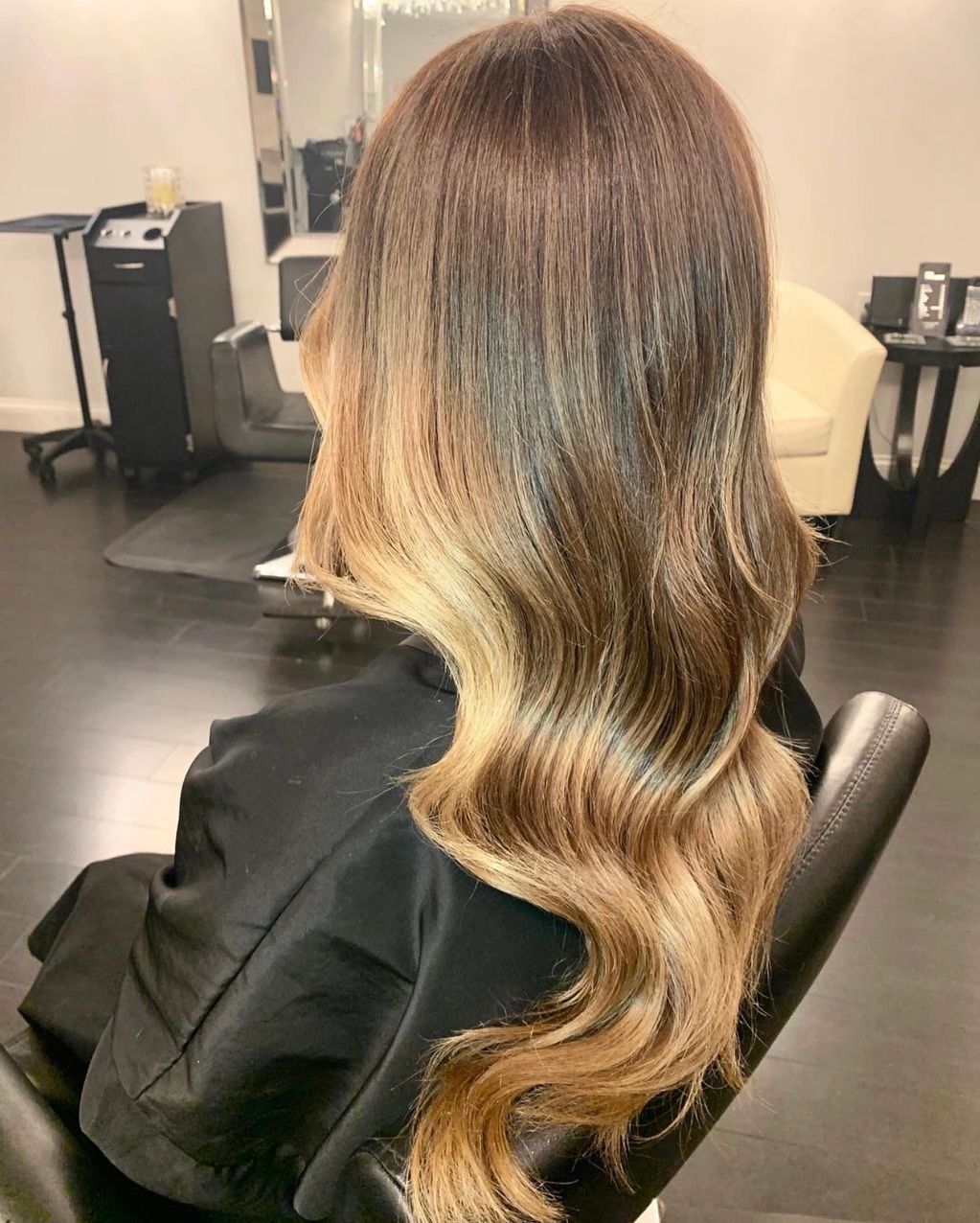 Long wavy hair with a smooth ombre transition from dark brown to blonde.