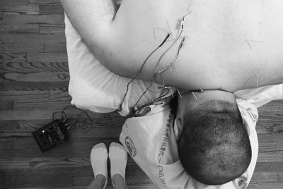 Patient lying face down getting electro-stimulation acupuncture on right upper back.
