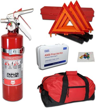 Emergency safety kit including fire extinguisher, warning triangles, first aid kit, fuses, and a red duffel bag.