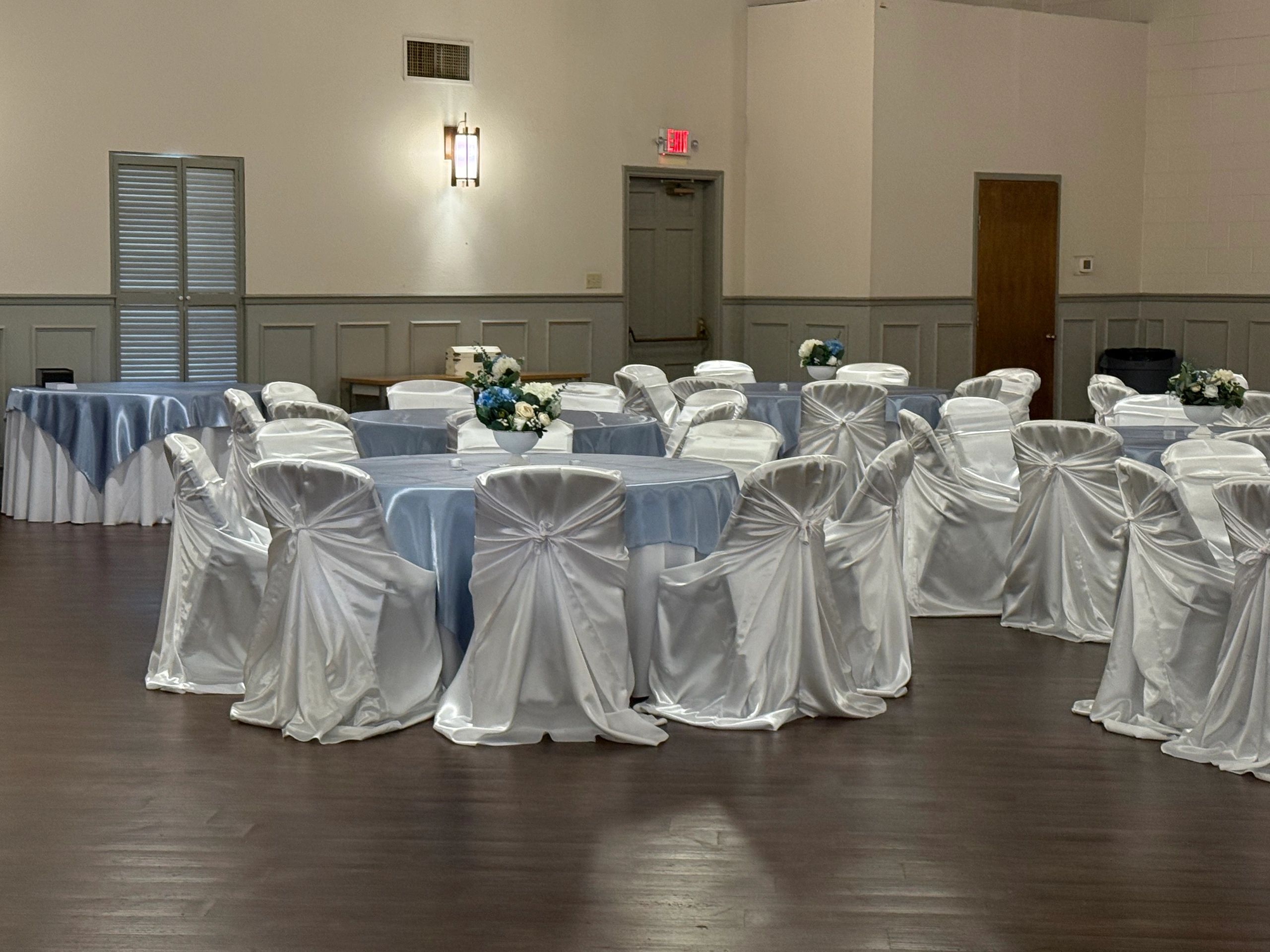 Empty banquet hall with decorated tables and chairs.