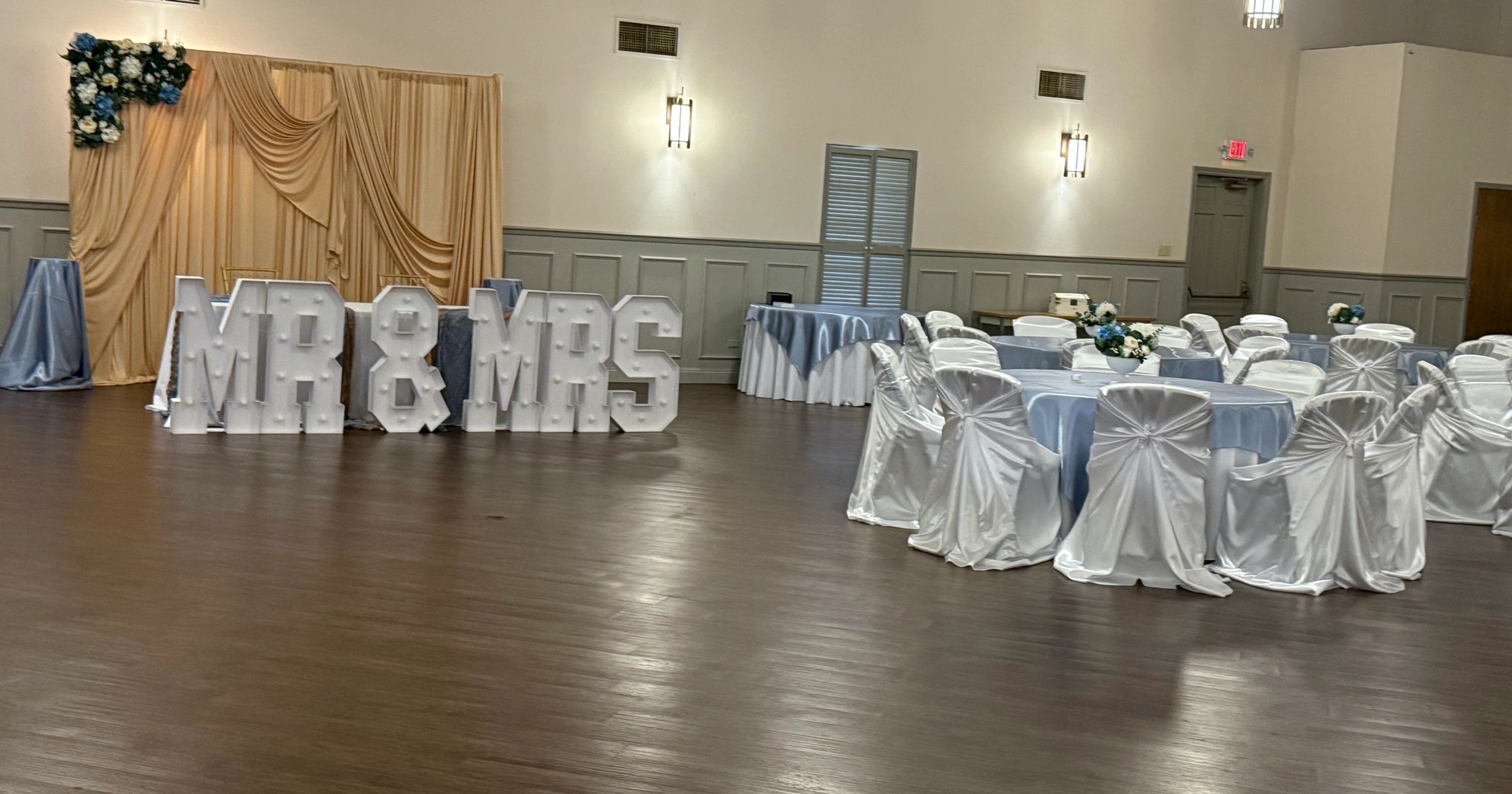 Wedding reception setup with "MR &amp; MRS" lighted letters.