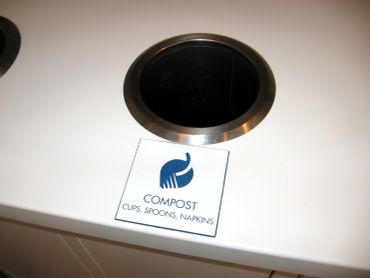 Compost bin for cups, spoons, and napkins.