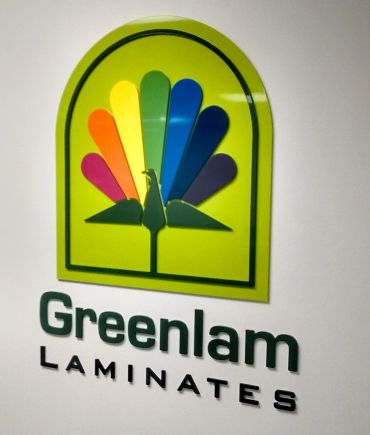 Greenlam Laminates logo with colorful peacock design.