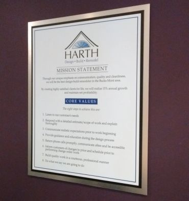 Framed mission statement and core values of Harth Design Build Remodel on a wall.
