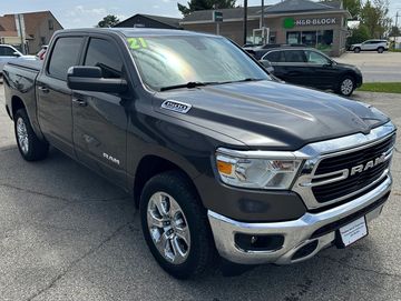Gray 2021 RAM pickup truck parked on asphalt near a street.