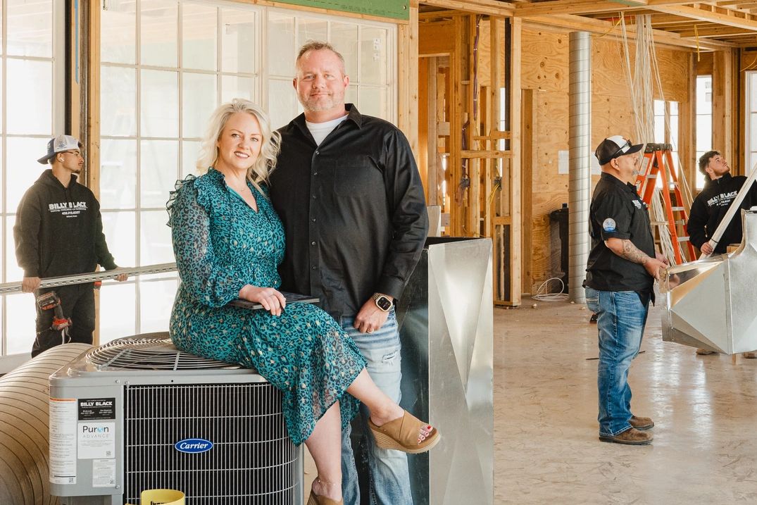 Group of people in a home under construction installing duct work and HVAC equipment