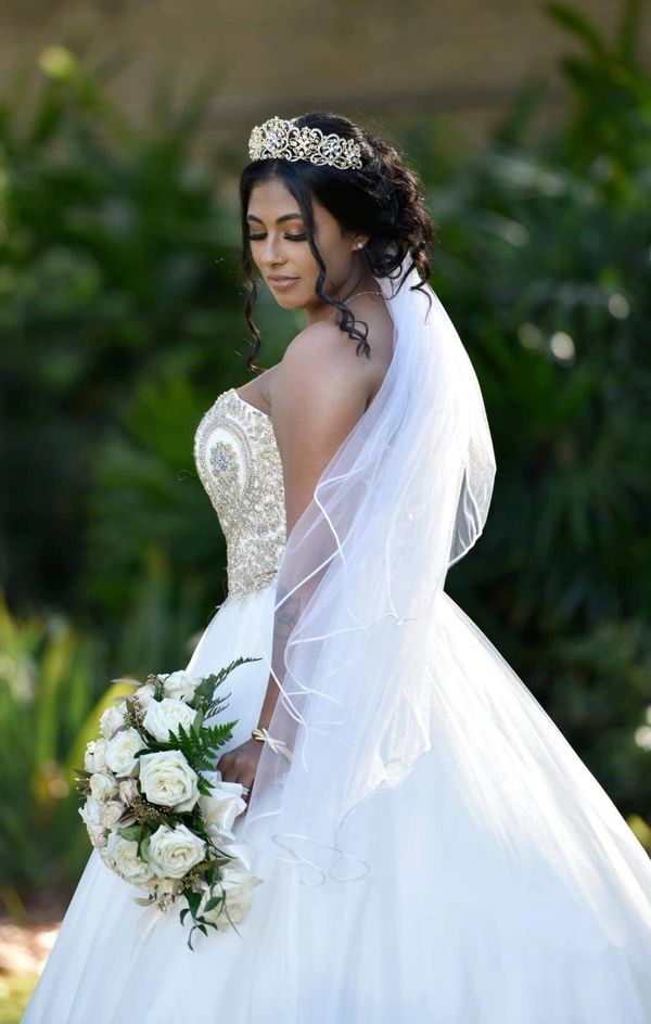 Makeup on a beautiful bride looking at her bouquet!