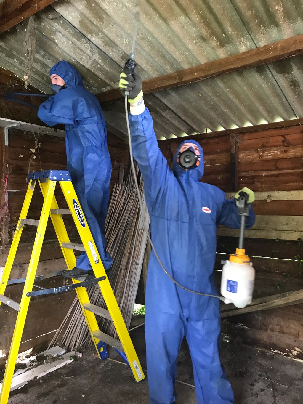 Spraying down asbestos cement roof sheets prior to removal works.