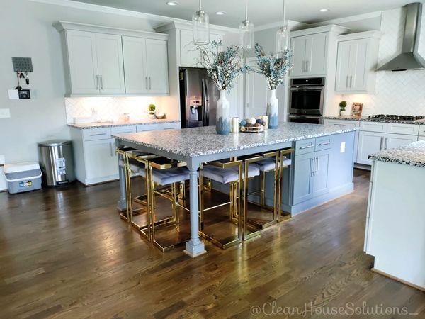 big modern kitchen. clean house solutions. granite countertops. gold stools. kitchen island. clean