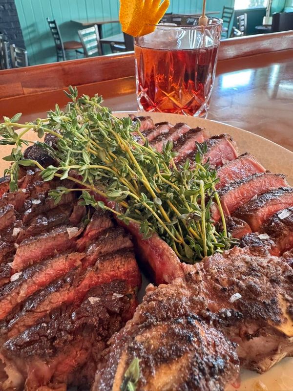 close up image of Porterhouse steak fillet off the bone with fresh herbs
