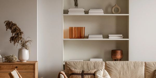 Neutral living room with built-in shelving, wood furniture and textured sofa