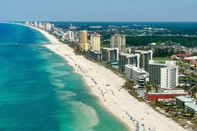 Aerial view of a city beach with buildings and ocean.