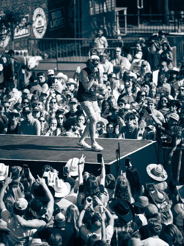 Artist performing on stage in front of a large crowd.