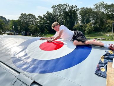Man putting graphic stickers on airplane wing