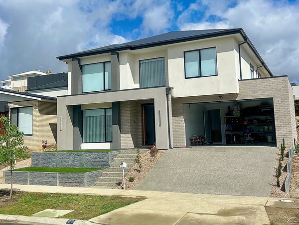 Modern two-story house with a sloped driveway and garage.